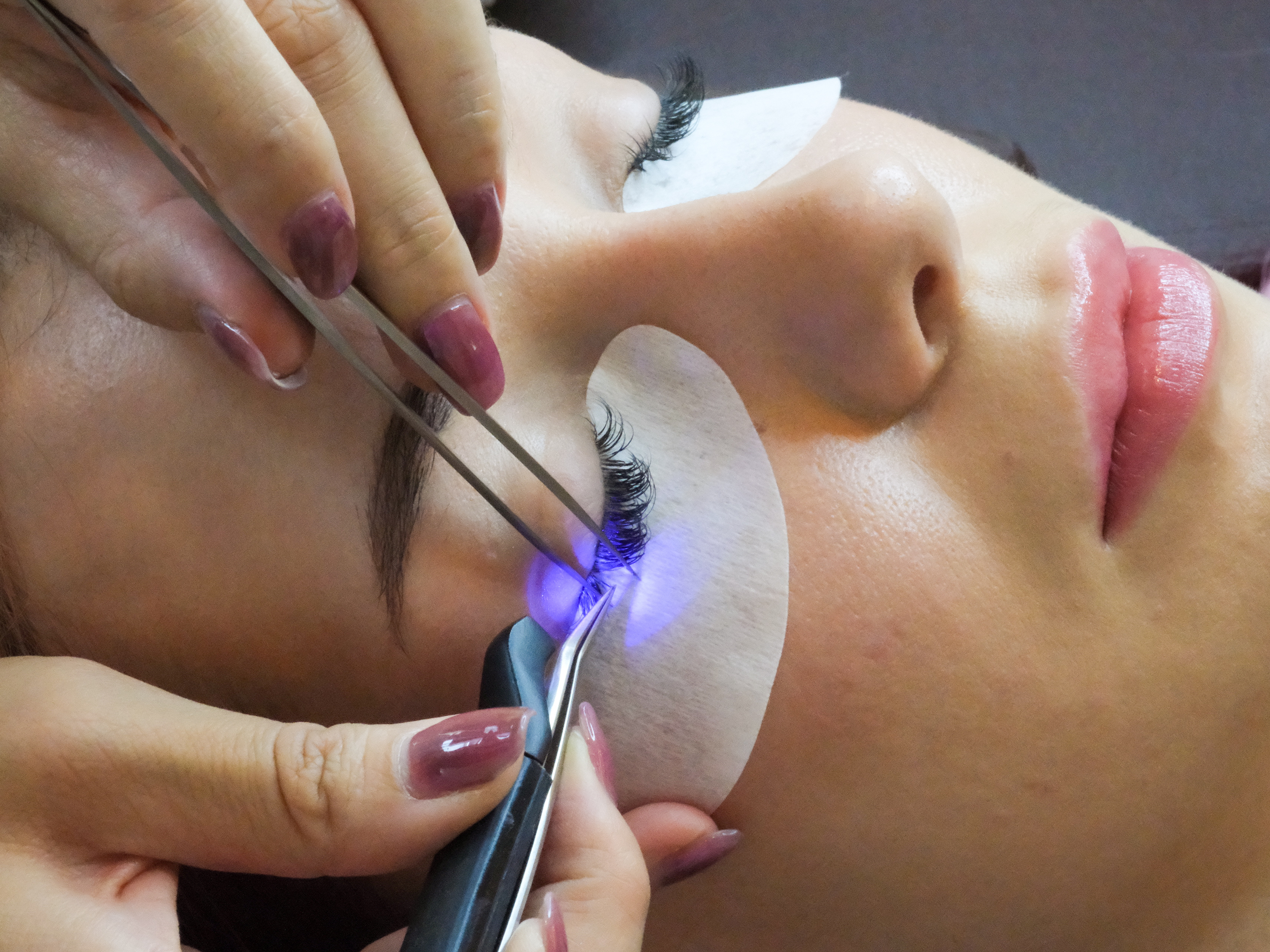The gentle UV LED light bonding a lash extension during a treatment at Evarin Lash & Beauty in Fortitude Valley — 100&times; gentler than salon-standard LED